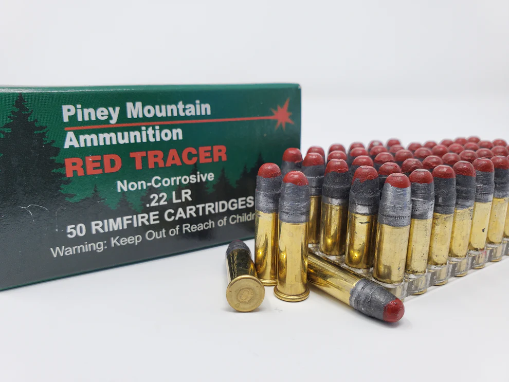 Box of Piney Mountain .22 LR Red Tracer Ammo with standing and laying rounds, showcasing bright red tracer bullets.