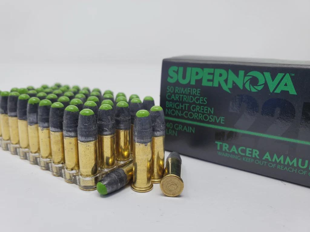 Supernova .22 LR Green Tracer Ammo box with an ammo holder displaying 50 rounds, four rounds in front—two standing, two lying down, showcasing bright green tracer tips.