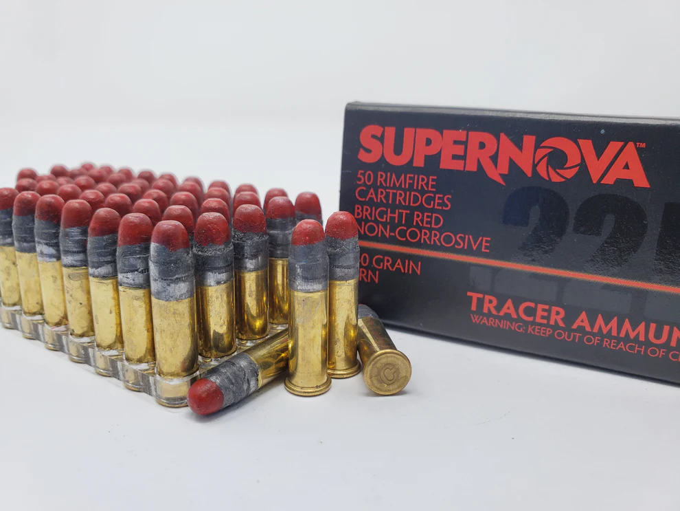 Supernova .22 LR Red Tracer Ammo box with an ammo holder displaying 50 rounds, four rounds in front—two standing, two lying down, showcasing bright red tracer tips.